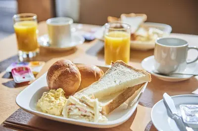 a table with a plate of breakfast foods and orange juice at Urayasu Sun Hotel - Vacation STAY 33001v in Urayasu