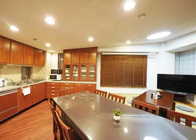a large kitchen with a table and wooden cabinets at \u9f8d\u99ac\u30b6\u30bf\u30ef\u30fc RYUMA The TOWER \u4e00\u68df\u8cb8\u5207\u306e\u5bbf in Tokyo