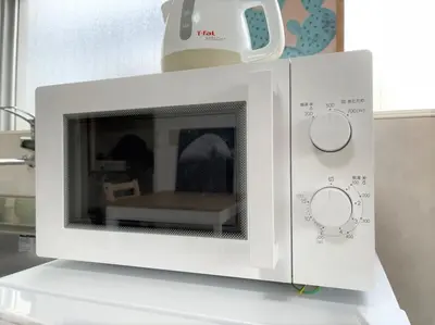 a white microwave oven on a counter in a kitchen at LUANAHOTEL IN WASEDA in Tokyo