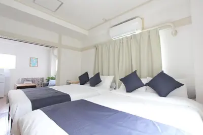 a bedroom with two beds with blue pillows at LUANAHOTEL IN WASEDA in Tokyo