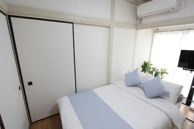 a bedroom with a white bed with white sheets and pillows at LUANAHOTEL IN WASEDA in Tokyo