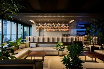 a lobby with a couch and a bar with plants at The Royal Park Canvas Ginza Corridor in Tokyo