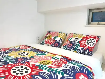 a bed with colorful sheets and pillows on it at KIKO HOUSE - Vacation STAY 42460v in Tokyo
