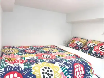 a bedroom with a bed with colorful sheets and pillows at KIKO HOUSE - Vacation STAY 42460v in Tokyo