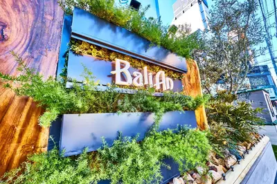 a sign on the side of a building with plants at Hotel BaliAn Resort Shinjuku Glamping in Tokyo
