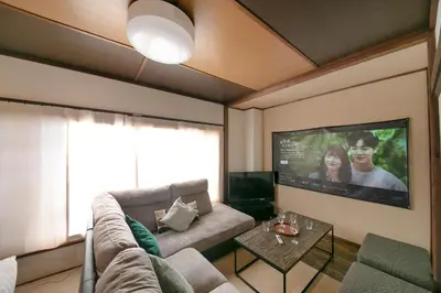 a living room with a couch and a flat screen tv at \u3077\u3075\u304b\u5c0f\u6885 in Tokyo