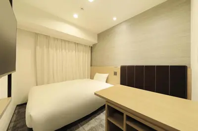 a small bedroom with a bed and a desk at Via Inn Prime Akasaka in Tokyo