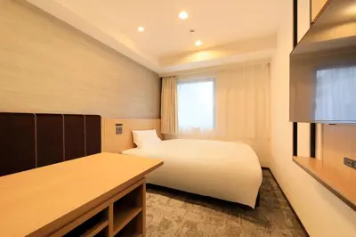 a bedroom with a white bed and a window at Via Inn Prime Akasaka in Tokyo