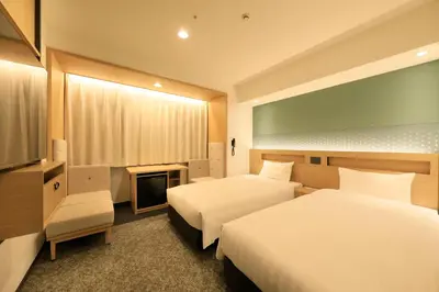 a hotel room with two beds and a television at Via Inn Prime Akasaka in Tokyo