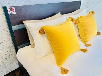a bed with yellow pillows andngthngthngthngthngth at TIME SHARING STAY Ikebukuro in Tokyo