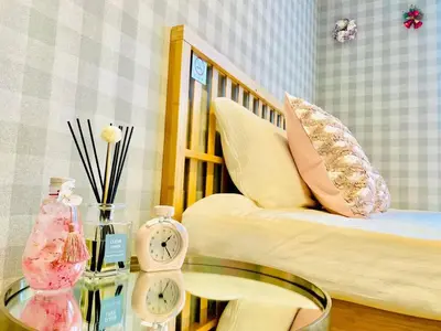 a room with a bed and a table with a clock at TIME SHARING STAY Ikebukuro in Tokyo