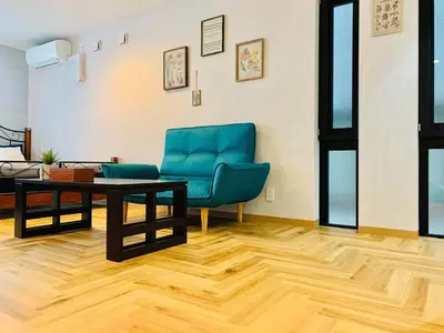 a living room with a blue couch and a table at TIME SHARING STAY Ikebukuro in Tokyo