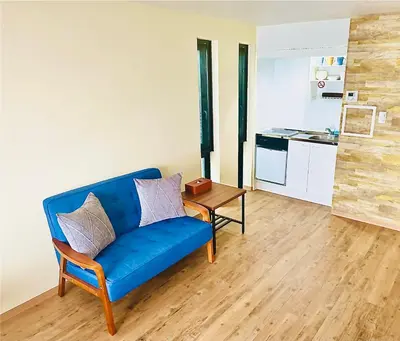 a living room with a blue couch and a table at TIME SHARING STAY Ikebukuro in Tokyo