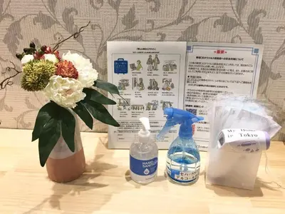 a table with a vase of flowers and a bottle of water at My Home in Tokyo - Vacation STAY 73238v in Tokyo
