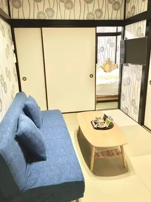 a living room with a blue couch and a table at My Home in Tokyo - Vacation STAY 73238v in Tokyo