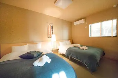 a bedroom with two beds and a window at Ciel-home in Tokyo