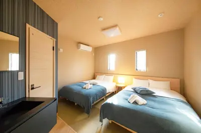 a bedroom with two beds and a bathroom with a television at Ciel-home in Tokyo