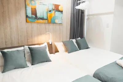 a hotel room with two beds and a painting on the wall at 15 min Shinjuku ! Kitchen,Laundry! Perfect for a Long Stay I many facilities nearby I Shinjuku,Tokyo in Tokyo