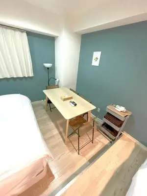 a room with a table and a bed at \u30b0\u30e9\u30f3\u30c7\u30a3\u30aa\u30fc\u30bd\u4e2d\u91ce\u5bcc\u58eb\u898b\u753a in Tokyo