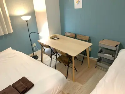 a room with a table and chairs and a bed at \u30b0\u30e9\u30f3\u30c7\u30a3\u30aa\u30fc\u30bd\u4e2d\u91ce\u5bcc\u58eb\u898b\u753a in Tokyo