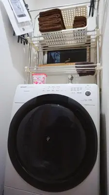 a washing machine in a laundry room with a shelf at K.House in Tokyo