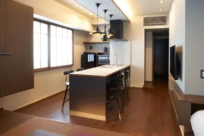 a kitchen with a counter and a kitchen island with stools at COCOSHUKU AKASAKA Premium in Tokyo
