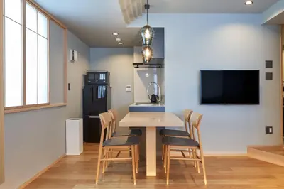 a dining room with a table and chairs and a tv at COCOSHUKU AKASAKA Premium in Tokyo