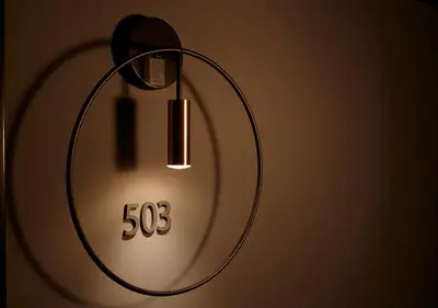a light on a wall with a clock on it at COCOSHUKU AKASAKA Premium in Tokyo