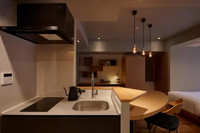 a kitchen with a sink and a table and a bed at COCOSHUKU AKASAKA Premium in Tokyo