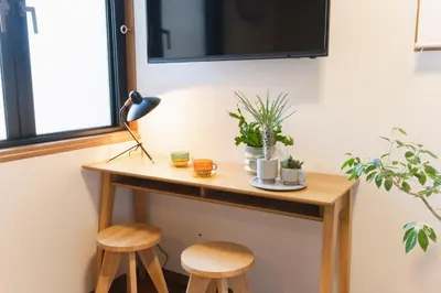 a small table with two stools next to a window at Near Ikebukuro, Kitchen & Laundry, Fast Wi-Fi, 4min to Station,Many restaurants nearby!! in Tokyo