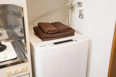 a towel sitting on top of a washer and dryer at Near Ikebukuro, Kitchen & Laundry, Fast Wi-Fi, 4min to Station,Many restaurants nearby!! in Tokyo