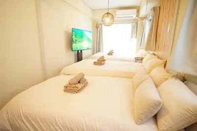 a bedroom with two beds with towels on them at \u5317\u65b0\u5bbf\u30a6\u30c3\u30c9\u30a6\u30a9\u30fc\u30eb\u30b9\u30c6\u30a4 in Tokyo