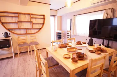 a dining room with a wooden table and a television at \u5317\u65b0\u5bbf\u30a6\u30c3\u30c9\u30a6\u30a9\u30fc\u30eb\u30b9\u30c6\u30a4 in Tokyo