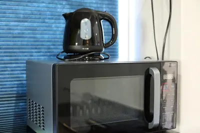 a black appliance sitting on top of a microwave at KANDA HOUSE!! Shin-Okubo Walkable Modern Stay with Shinjuku Access in Tokyo