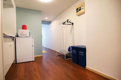 a room with a refrigerator and a microwave on a wall at GM Shinjuku in Tokyo
