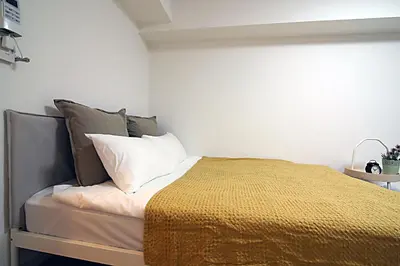 a bedroom with a bed with a yellow blanket at GM Shinjuku in Tokyo
