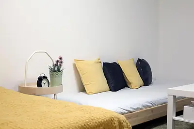 a bed with yellow and black pillows in a room at GM Shinjuku in Tokyo