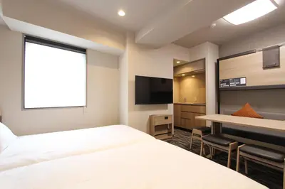 a hotel room with a bed and a desk and a television at KOKO HOTEL Residence Asakusa Tawaramachi in Tokyo
