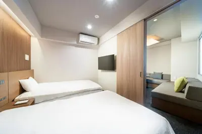 a hotel room with a bed and a couch at KOKO HOTEL Residence Asakusa Tawaramachi in Tokyo