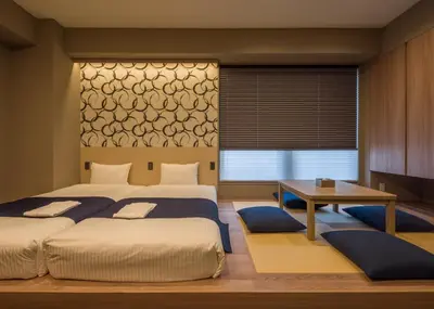 a bedroom with two beds and a table and a desk at KOKO HOTEL Residence Asakusa Kappabashi in Tokyo