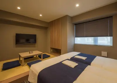 a bedroom with a bed and a table and a tv at KOKO HOTEL Residence Asakusa Kappabashi in Tokyo