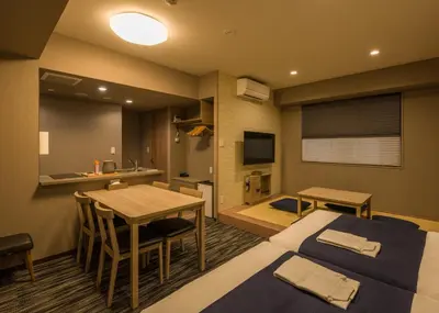 a hotel room with two beds and a table and a kitchen at KOKO HOTEL Residence Asakusa Kappabashi in Tokyo