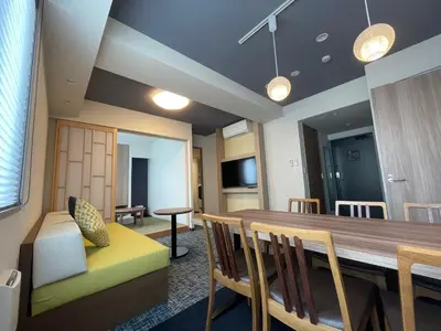 a dining room with a table and a couch at KOKO HOTEL Residence Asakusa Kappabashi in Tokyo