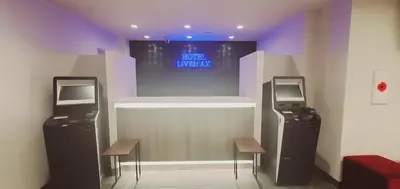two arcade machines in a room with two stools at HOTEL LiVEMAX Kamata Ekimae in Tokyo