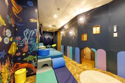 a childrens play room with a colorful wall at Holy Town in Tokyo