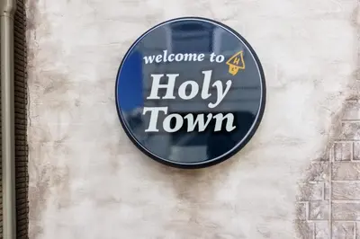 a welcome to a holy town sign on a wall at Holy Town in Tokyo