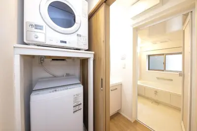 a kitchen with a microwave and a washer and dryer at Holy Town in Tokyo