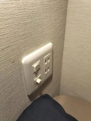 a light switch on a wall next to a toilet at bnb plus Ueno Park Female only in Tokyo