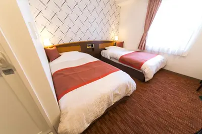 a hotel room with two beds and a window at Hotel New Ueno in Tokyo