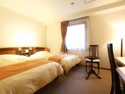 a hotel room with two beds and a window at Hotel New Ueno in Tokyo